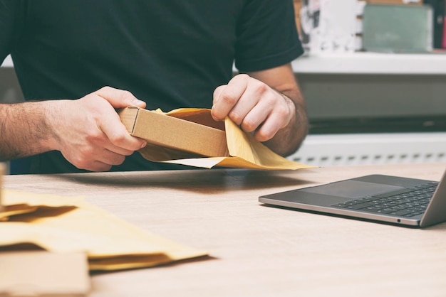 L'homme emballe le produit dans l'enveloppe jaune