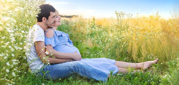 L'homme embrasse le ventre d'une femme enceinte sur la nature