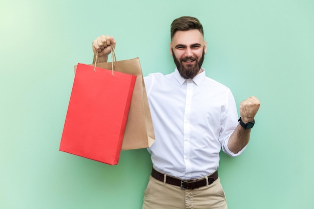 Homme émotif en chemise blanche près de fond vert