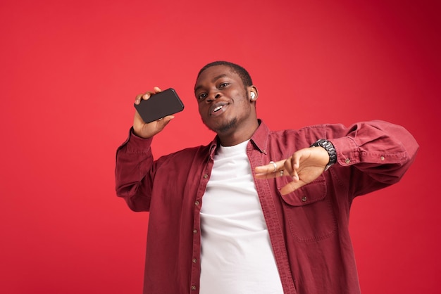 Homme émotionnel apparence africaine avec téléphone dans les mains technologie communication joie