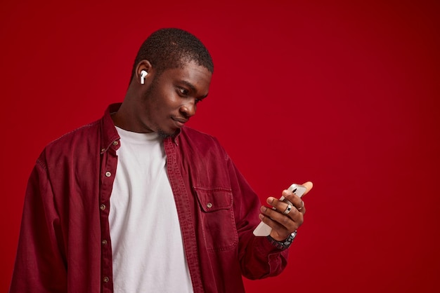 Homme émotionnel apparence africaine avec téléphone dans les mains technologie communication joie
