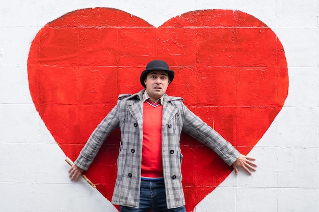 Homme émotionnel sur un fond de coeur de mur de briques Concept et symbole d'amour brisé