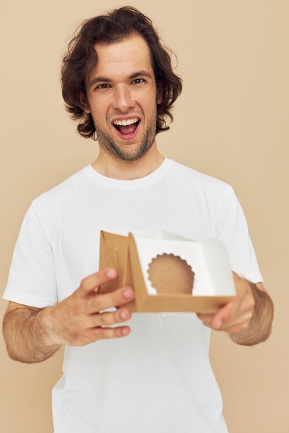 Homme émotionnel avec petite boîte cadeau sur fond beige