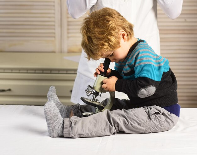 Un homme et un enfant au visage occupé jouent au médecin ou au scientifique