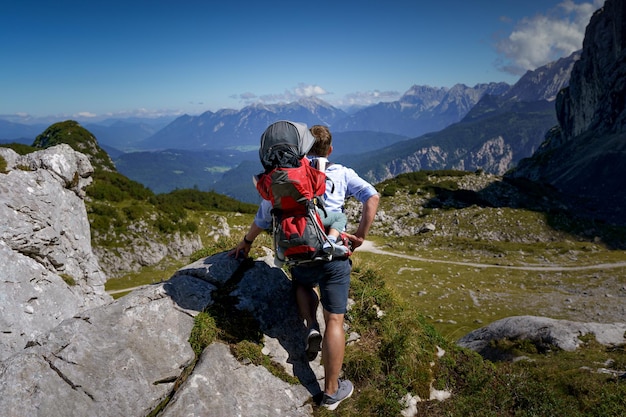 Homme avec enfant sur le dos regarde au loin