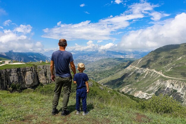 Un homme avec un enfant sur le fond d'une vue sur le plateau de Matlas district de Khunzakhsky Daghestan Russie 2021