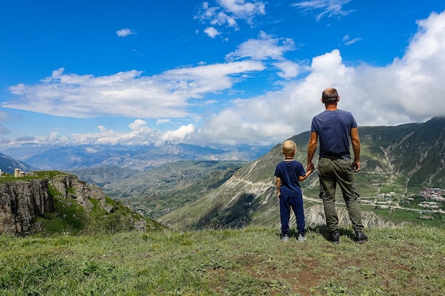 Un homme avec un enfant sur le fond d'une vue sur le plateau de Matlas district de Khunzakhsky Daghestan Russie 2021