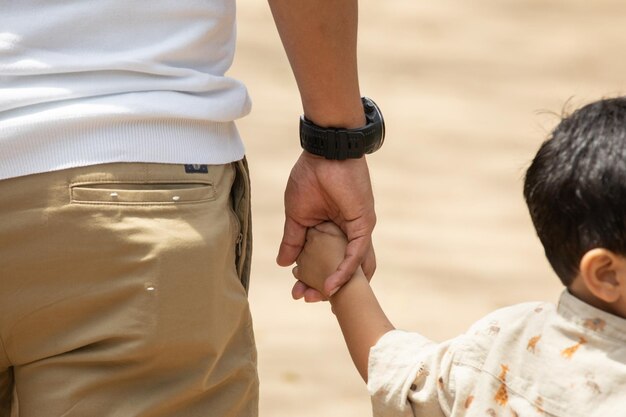 Photo un homme et un enfant se tiennent la main avec une montre au poignet