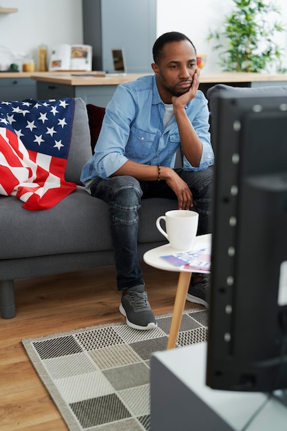 Un homme ennuyé devant la télé.