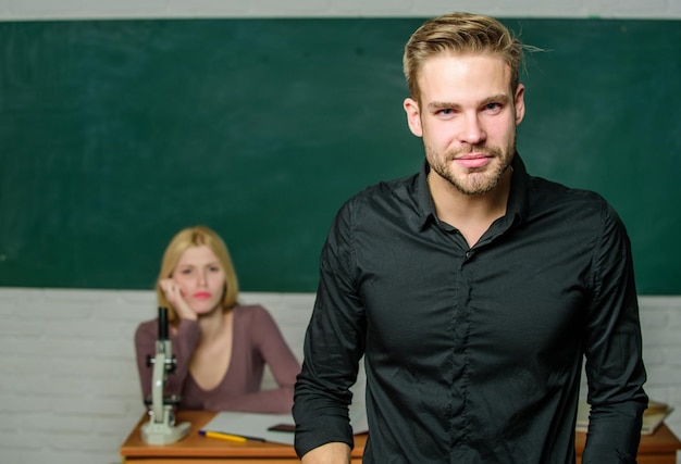 Homme enseignant attrayant bien soigné devant la salle de classe. Obsédé par la connaissance. Professeur de ses rêves. Beau professeur. Enseignement scolaire et collégial. Diplômé avec succès. Mentorat des jeunes.