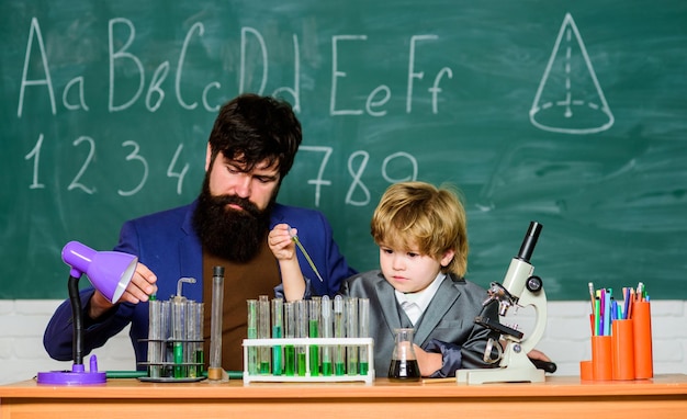 Homme enseignant avec petit garçon Biologie Laboratoire de sciences Retour à l'école père et fils à l'école apprenant la chimie dans le laboratoire de l'école Recherche et expériences scientifiques La fission disparue