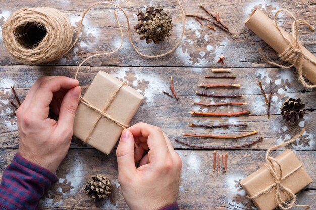 Homme enveloppe des cadeaux de Noël en bois