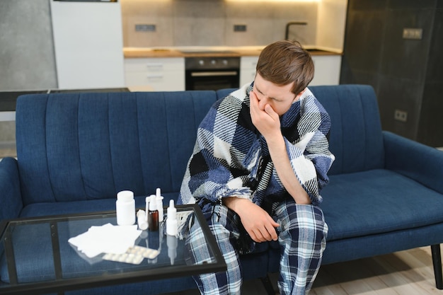 Photo homme enveloppé dans un plaid sur le canapé se sentant malade à la maison