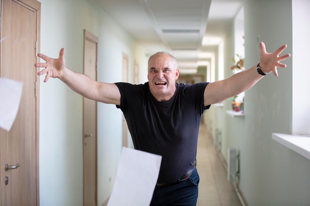 Un homme éparpille des draps Panne Stress au travail Un homme en colère dans le couloir jette du papier