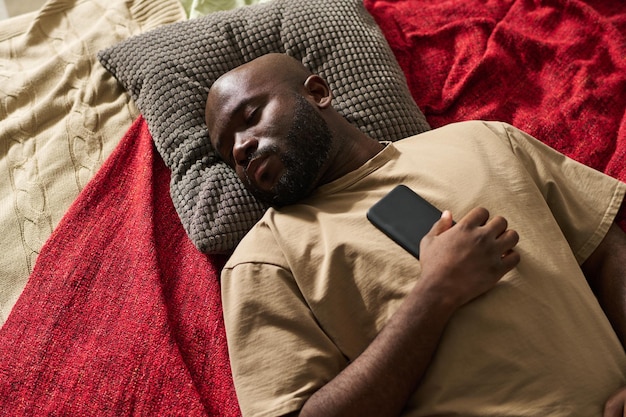 Homme épuisé dormant sur le lit