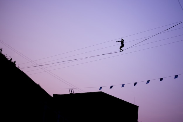 Homme en équilibre sur une corde contre le ciel