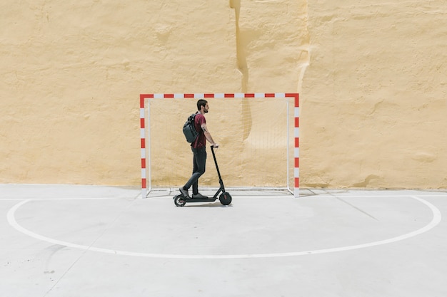 Photo homme, équitation, e-scooter, sur, cour de handball