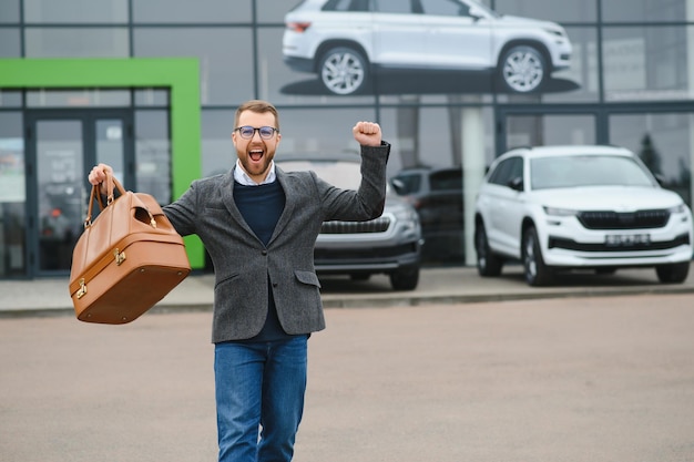 Homme d'esprit client acheteur masculin client en costume choisir auto pour aller regarder de côté vouloir acheter une nouvelle automobile dans la salle d'exposition de voitures salon de véhicules concessionnaire magasin salon de l'automobile concept de vente intérieur