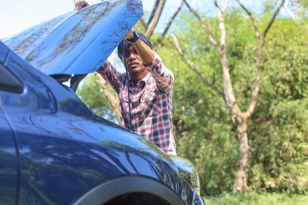 Photo un homme essaie de résoudre un problème de moteur de voiture sur une route personnes ayant un problème de voiture concept de transport