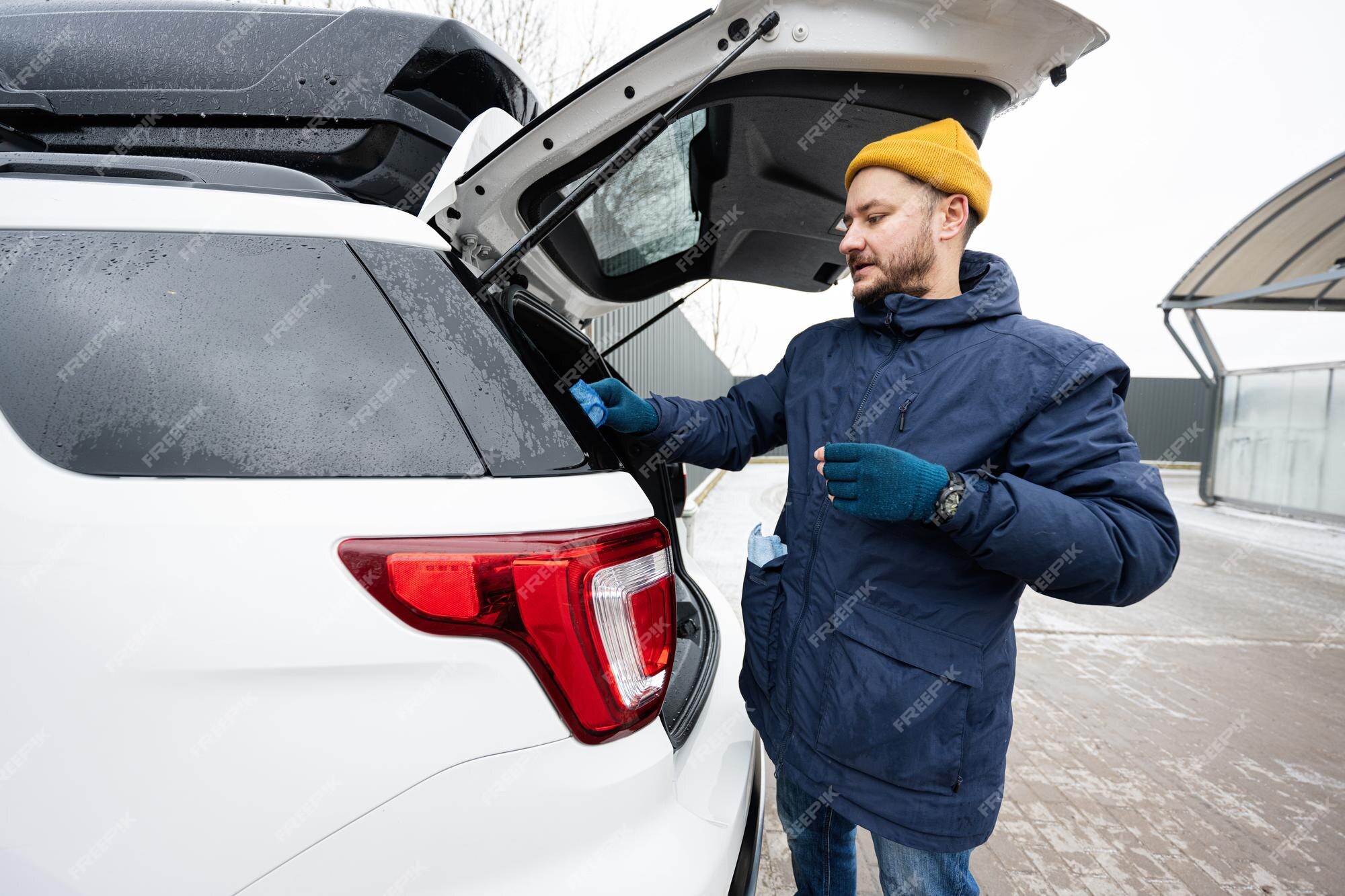 l'homme essuie la voiture suv américaine avec un chiffon en