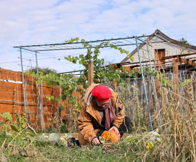 Photo un homme est agenouillé dans l'herbe avec un chapeau rouge sur