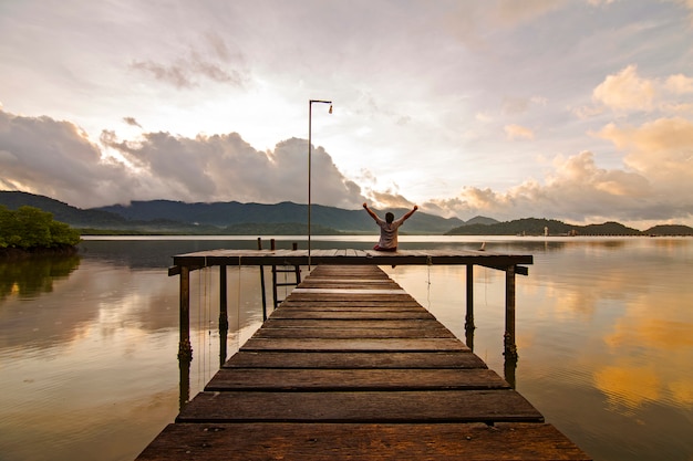 Photo l'homme est assis en arrière et appréciant le paysage tôt le matin.