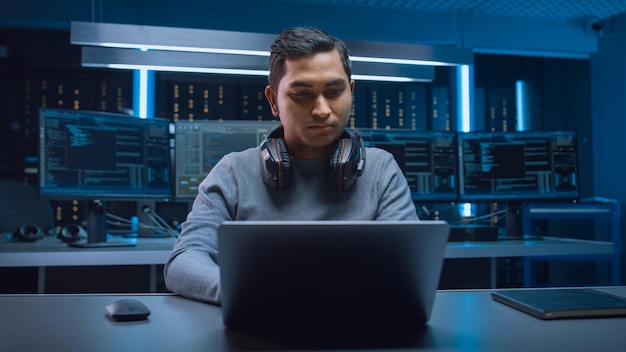 Un homme est assis à un bureau devant un ordinateur avec un casque.