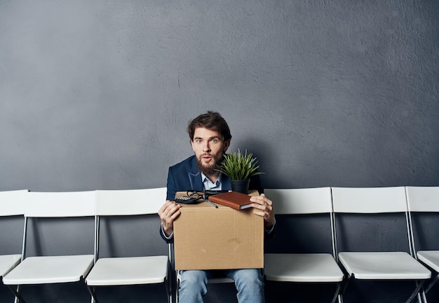 L'homme est assis sur une chaise avec des choses rejetant la dépression de mécontentement