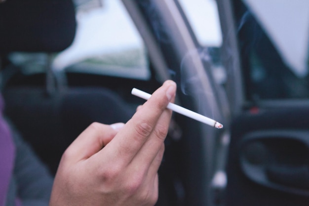 Un homme est assis dans une voiture et fume