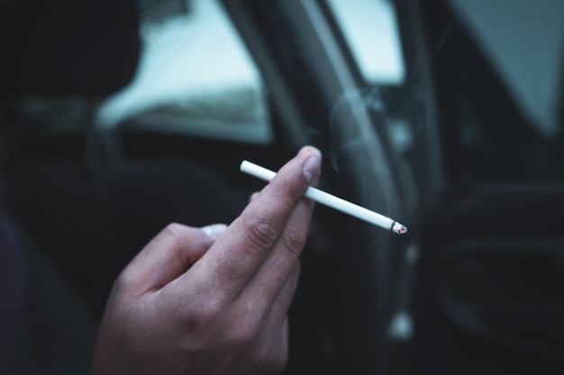 Un homme est assis dans une voiture et fume