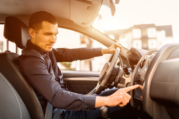 Un homme est assis dans une voiture. Intérieur du véhicule. Homme affaires, conduite