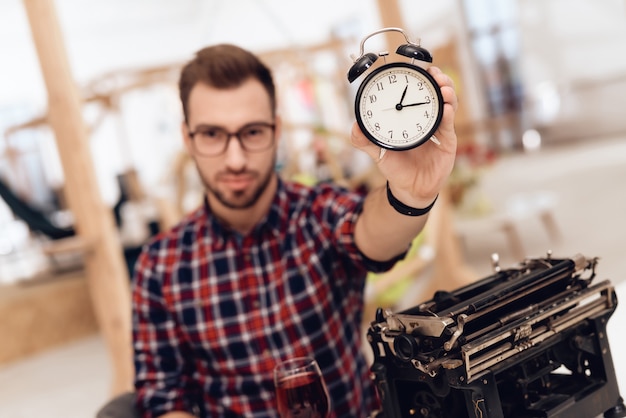 Photo un homme est assis et montre une montre à la caméra.