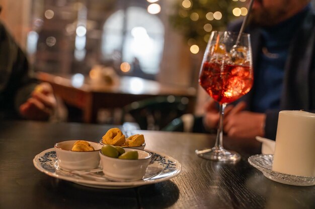 Un homme est assis à une table avec un verre de vin et une assiette de nourriture