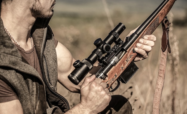 L'homme est en chasse. Fusil de chasse de chasse. Homme chasseur. Période de chasse. Homme avec une arme à feu. Fermer. Chasseur avec fusil de chasse et formulaire de chasse pour chasser. Hunter vise. Observation du tireur dans la cible.