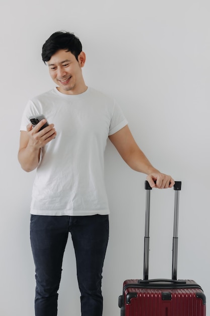 L'homme est debout avec une mallette en utilisant un téléphone portable