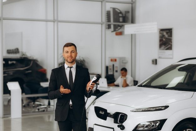 L'homme est directeur des ventes d'une voiture électrique.