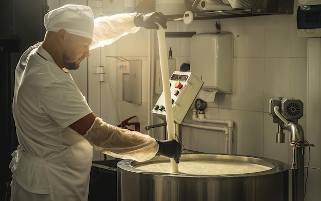 L'homme est un fromager en train de produire différentes variétés de fromage dans l'industrie La fabrication du fromage au lait