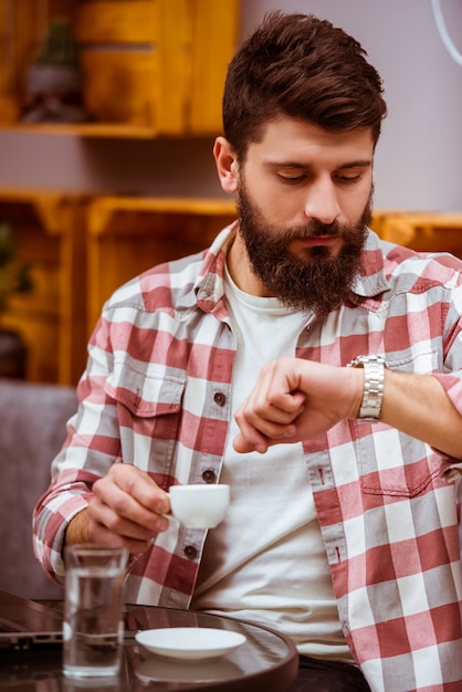 Un homme est sorti pour une pause-café et boit du café.