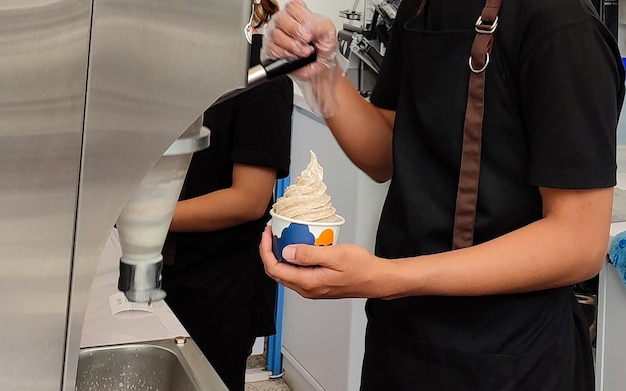 Photo un homme est swirl ice cream avec des fruits congelés