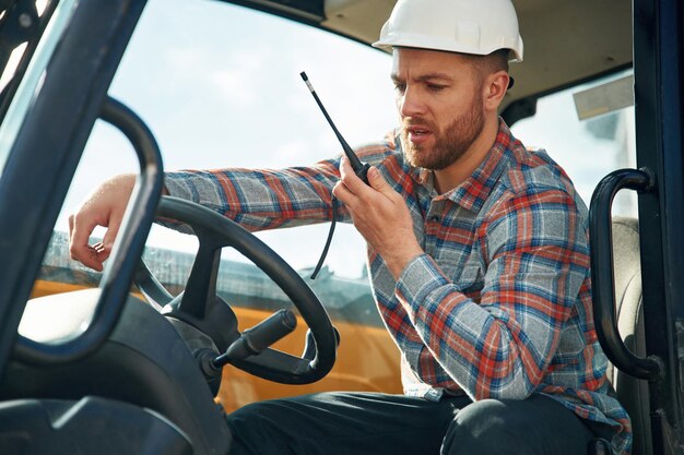 Photo l'homme est avec le tracteur ouvrier agricole