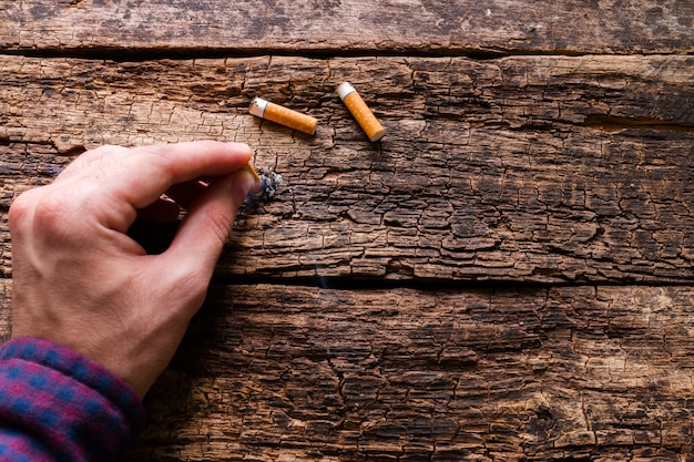 Un homme éteint une cigarette