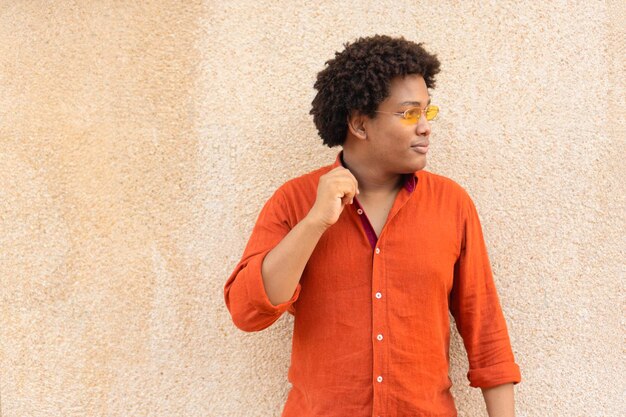 Homme ethnique cool avec des lunettes de soleil regardant d'un côté