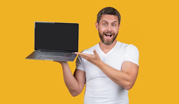 Homme étonné présentant un ordinateur portable en studio homme montrant un ordinateur portable homme présentant un écran