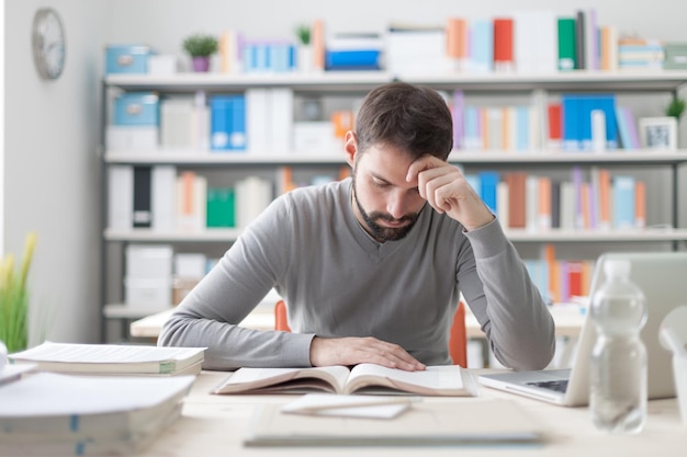 Homme étudiant à la bibliothèque