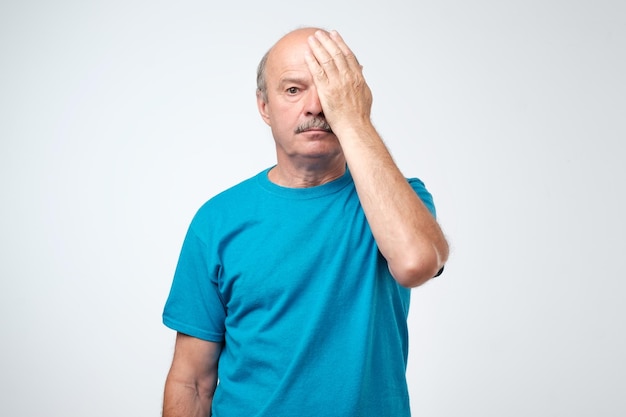 Homme européen de nature fatigué couvrant un œil avec la paume comme s'il avait testé ses yeux lors d'un examen de la vision