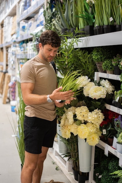 Homme examinant l'herbe en pot en boutique