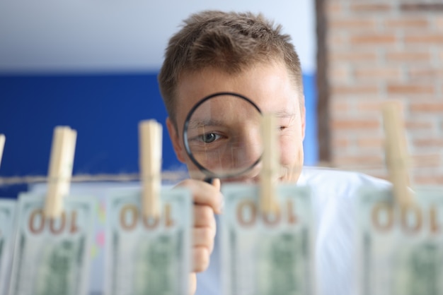 L'homme examine l'argent à la loupe