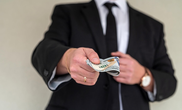 Photo un homme exceptionnel avec de belles mains fortes doit remettre une grosse somme d'argent aux travailleurs grand et petit concept d'entreprise