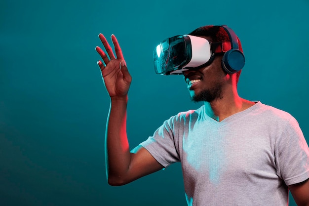 Homme excité jouant à un jeu virtuel sur un casque vr interactif, s'amusant avec la technologie 3d moderne. Personne utilisant un appareil futuriste avec simulation visuelle et innovation technologique, activité de loisirs.