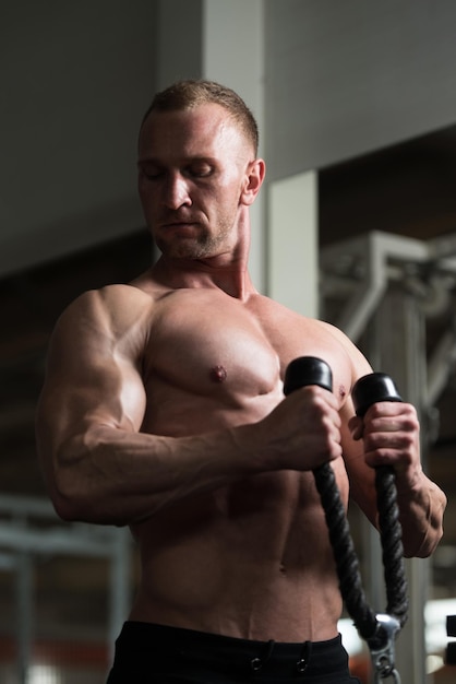 Homme exerçant des biceps dans la salle de gym